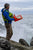 An orange A4 waterproof clipboard being used for coastal surveying.